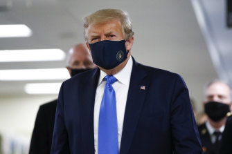 President Donald Trump wears a mask as he walks down the hallway during his visit to Walter Reed National Military Medical Centre.