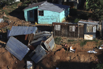 在德班的一個非正式定居點，一名年輕女孩坐在損壞的棚屋旁，那裡的洪水已造成數百人死亡。