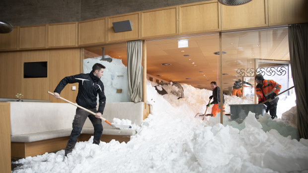 People clear snow from inside the Hotel Saentis in Schwaegalp, Switzerland, on Friday.
