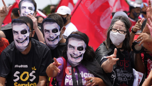 Demonstrators wear masks representing Brazilian President Jair Bolsonaro as they protest his government’s handling of the COVID-19 pandemic outside Planalto presidential palace in Brasilia, Brazil.