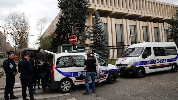 Police officers and riot police officers stand outside the Russian embassy in Paris, after France expelled diplomats in a coordinated action.