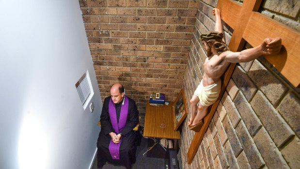 Father Nicholas Pearce in the confessional at Holy Family Church in  Mount Waverley.