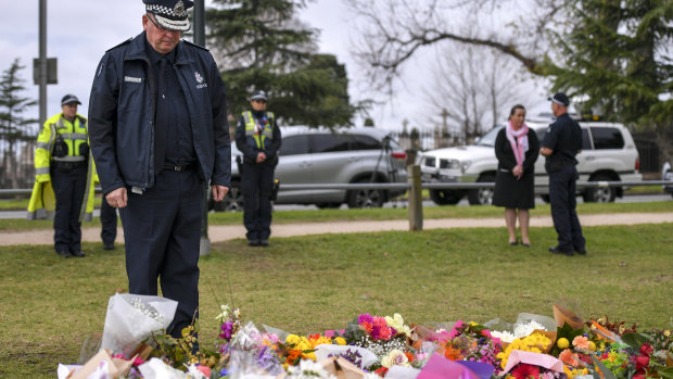 Graham Ashton, Chief Commissioner of Victoria Police, lays flowers at the make shift memorial where Eurydice Dixon's body was found at the Princes Park, North Carlton. 18 June 2018. The Age News. 
