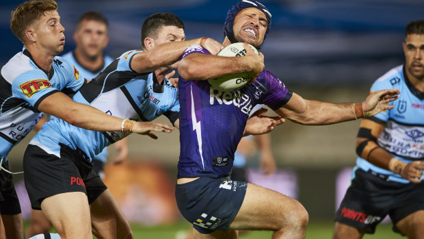 Jahrome Hughes of the Storm is tackled by the Sharks at Jubilee Stadium.