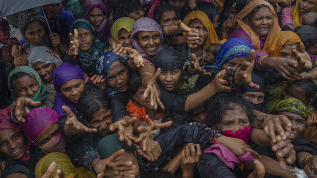 Rohingya Muslim women, who crossed over from Myanmar into Bangladesh, stretch their arms out to collect sanitary products distributed by aid agencies near Balukhali refugee camp, Bangladesh. 