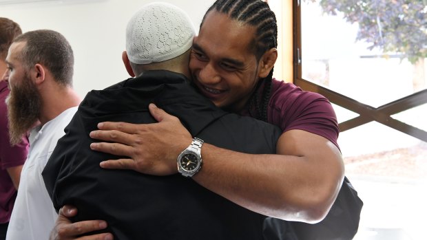 Manly hug: Martin Taupau embraces a worshipper.
