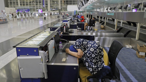 Stranded travellers sleep at the check-in counters at the Hong Kong International Airport.