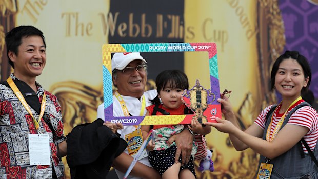 Fans pose outside the stadium prior to Wales' World Cup opener against Georgia in Toyota City on Monday.