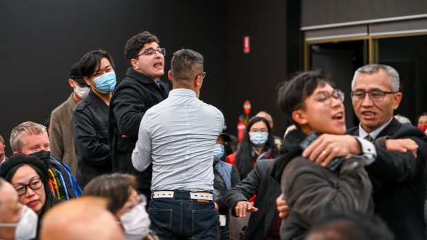 Two men who disrupted the forum are escorted from the hall.