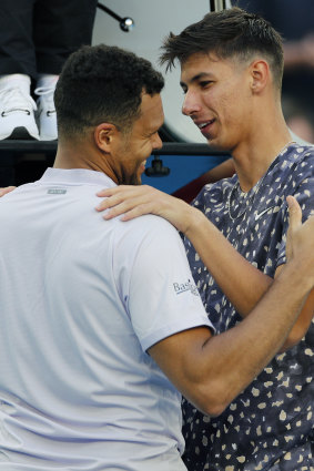 Alexei Popyrin consoles Jo-Wilfried Tsonga after the Frenchman pulled out of their match.