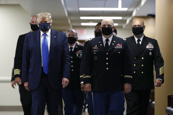 President Donald Trump with men in black masks.