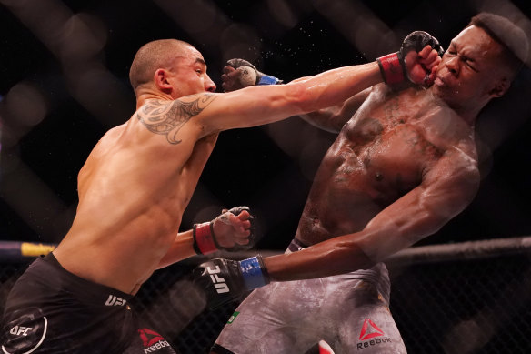 Robert Whittaker (left) got some hits in before his defeat to Israel Adesanya (right). 