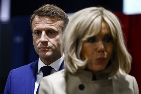 French President Emmanuel Macron and his wife Brigitte Macron stand in the voting station before voting in Le Touquet-Paris-Plage.
