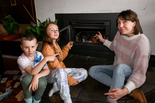 Possums in the home: Monica Elith and sons Lucas, 10, and Zachary, 7, with the wood heater that two possums fell into from the roof.