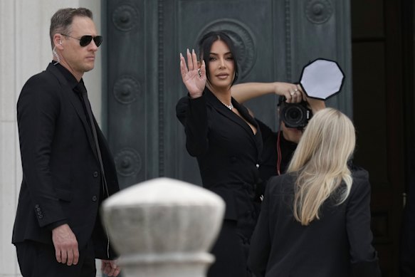Kim Kardashian waves as she arrives to testify regarding a robbery of millions of dollars in jewels from her Paris hotel room in 2016.