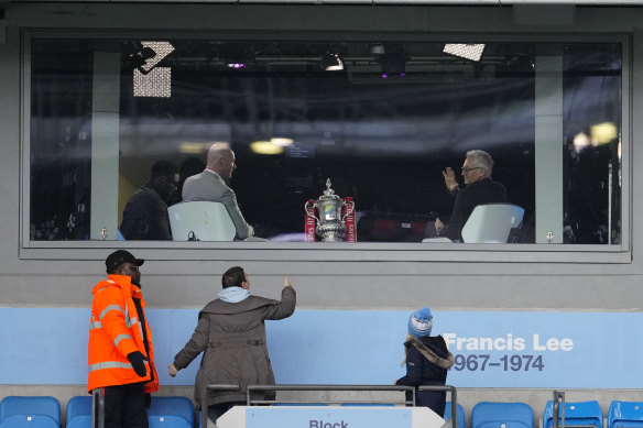 A fan photographs Gary Lineker, right, before the English FA Cup quarter-final match between Manchester City and Burnley.
