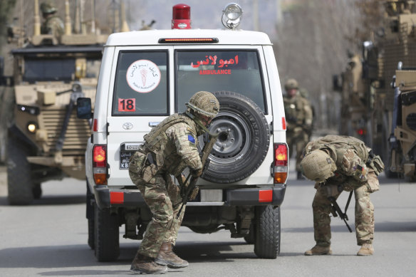 British soldiers with NATO-led Resolute Support Mission check an ambulance at the site of an attack attacked on a remembrance ceremony for a minority Shiite leader in 2020.