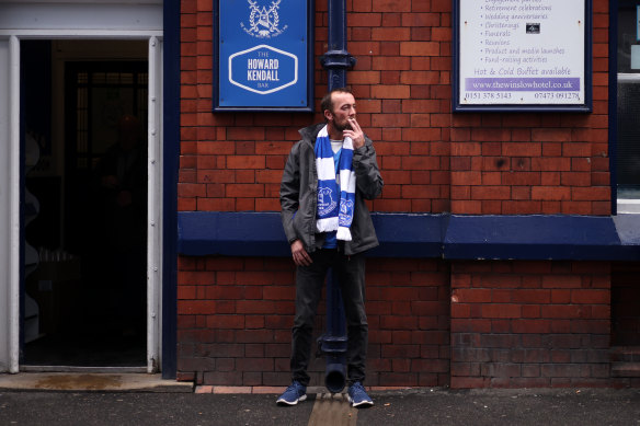 A soccer fan smokes a cigarette outside a pub in Liverpool.