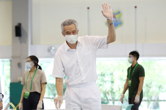 Singapore Prime Minister Lee Hsien Loong waves as he casts his vote on Friday.