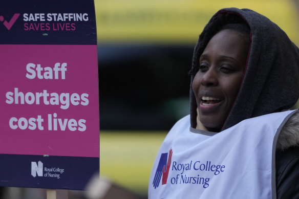 A nurse holds a placard on the picket line as she participates in a strike action over pay in London in December.