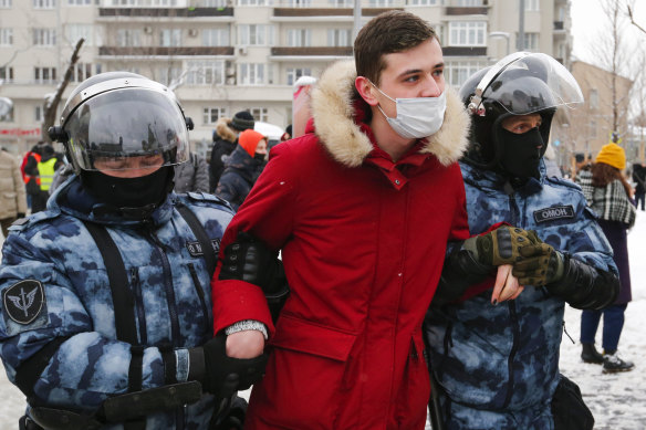 Police officers in Moscow detain a man during a protest against the jailing of opposition leader Alexei Navalny.