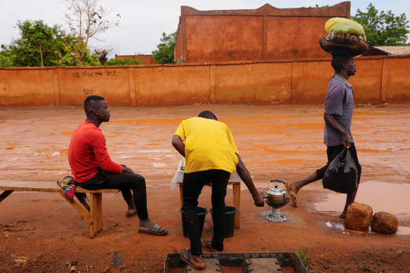 Shopkeepers take tea near the entrance of the airport in Niamey, Niger, on Tuesday.