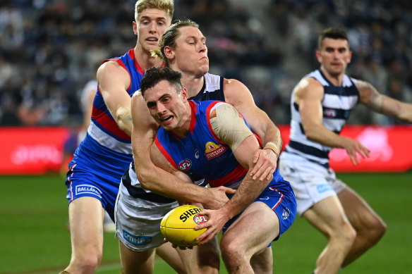 Toby McLean is tackled by Mark Blicavs.