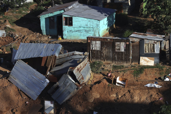 A young girl sits next to a damaged shack at an informal settlement in Durban, where floods have killed hundreds of people.