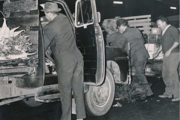 Police search for weapons during a dawn raid in 1964 on Victoria Market as part of an investigations into mafia-style shootings.