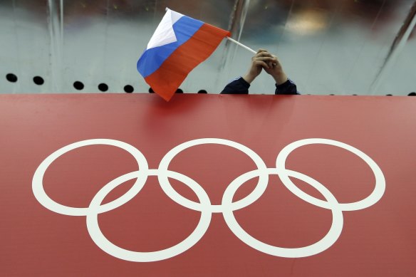 A Russian flag is held above the Olympic Rings at Adler Arena Skating Centre during the Winter Olympics in Sochi, Russia in 2014. 