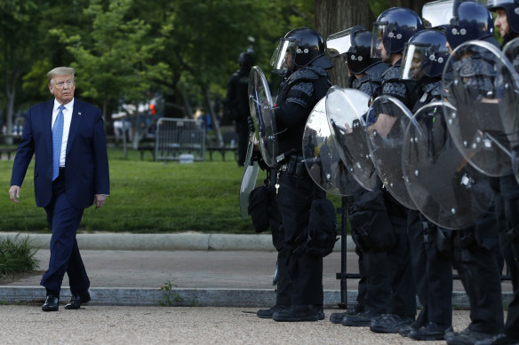 President Donald Trump walks past police in Lafayette Park after visiting outside St John's Church across from the White House on Monday.