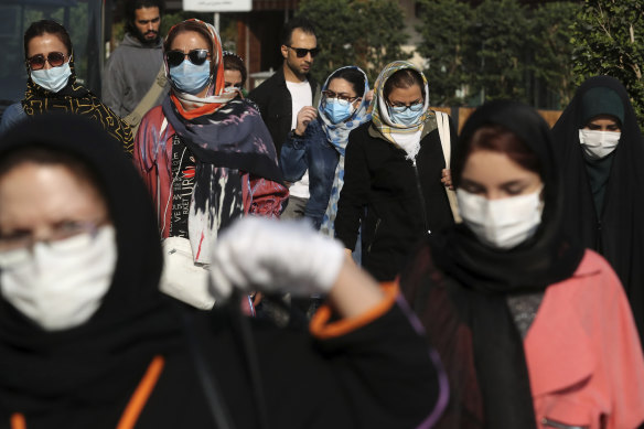 People wear protective face masks to help prevent the spread of the coronavirus in downtown Tehran, Iran, on Sunday, October 11.