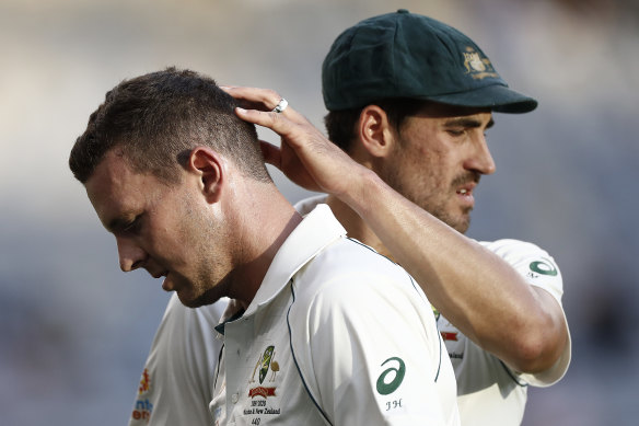 Josh Hazlewood is consoled by Mitchell Starc after injuring his hamstring in Perth.