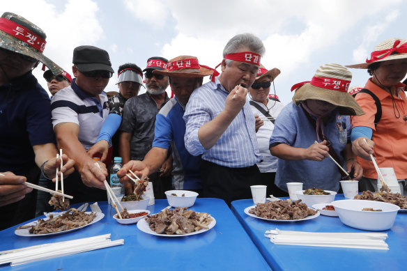 Korean Dog Meat Association members eat dog meat during a rally in support of the controversial, but traditional, cuisine, in 2019.