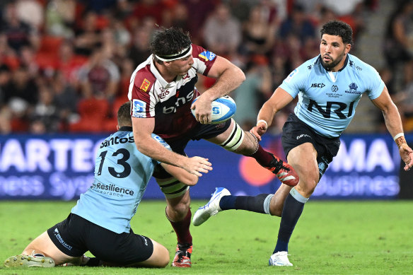 Ryan Smith of the Reds is tackled against the Waratahs