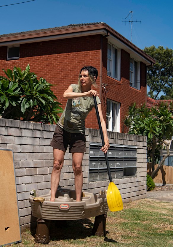 Marina DeBris in a child’s toy boat that has been dumped on the street in Coogee.