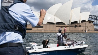 A man holds up a fire extinguisher during a NSW Maritime safety check on Saturday.