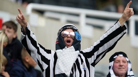 A Newcastle United fan celebrates the side’s first home match since a Saudi-backed takeover last month.