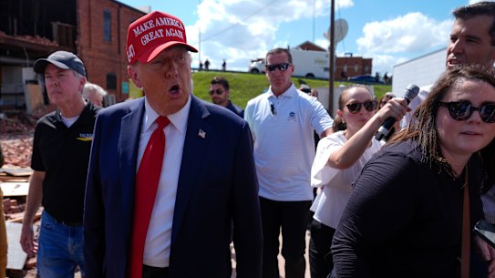 Republican presidential nominee former President Donald Trump walks outside a furniture store as he visits Valdosta, Georgia, a town impacted by Hurricane Helene.