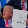 President Donald Trump signs his signature bill into law.