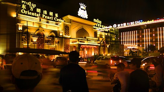 Cambodian motorbike and tuk tuk drivers wait for customers outside the Oriental Pearl Casino and the Gobo East Casino in Sihanoukville in 2018.