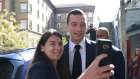 Far-right National Rally party president Jordan Bardella poses for a selfie after voting in Garches, outside Paris.