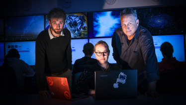 Dr Igor Andreoni (left), Sara Webb and Professor Jeff Cooke in mission control. Behind them sit the team hunting for FRBs.
