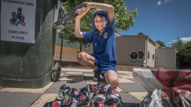 Eco-detective at Garran Primary Rex Martin, 10, crushes collected cans as part of the school's extensive recycling program.