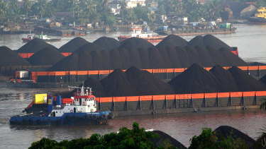 Tugboats guide barges transporting coal in Indonesia.