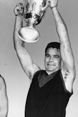 Ron Barassi holds the 1964 premiership cup aloft after the Demons triumph over Collingwood.
