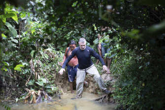 British journalist Dom Phillips, right, and a Yanomami Indigenous man walk in Maloca Papiu village, Roraima state, Brazil, in 2019.