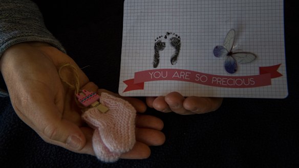Ali holds mementos of her daughter who had developed severe abnormalities in utero.  
