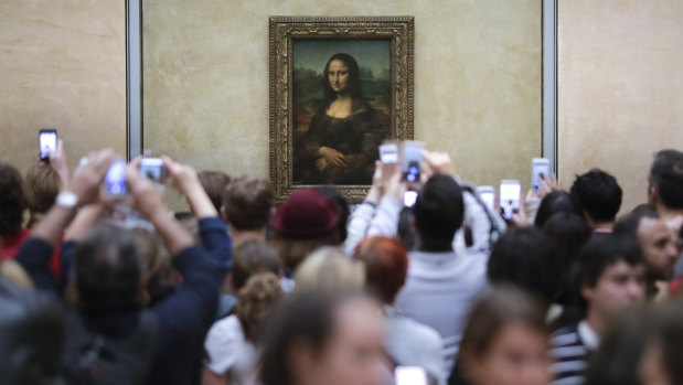 Visitors crowd in front of Leonardo da Vinci's painting Mona Lisa at The Louvre in Paris. 