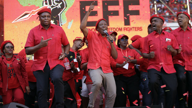 Leader of the Economic Freedom Fighters (EFF) party, Julius Malema, centre, sings and dances with party members at an election rally in Soweto, South Africa.